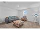 Bright living room features neutral tones, plush seating, and a window letting in natural light at 293 Pineywoods St, St Cloud, FL 34772
