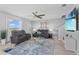 Inviting living room featuring leather seating, a ceiling fan, and a view of the backyard through a large window at 293 Pineywoods St, St Cloud, FL 34772