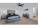 Main bedroom featuring carpet, neutral walls, modern ceiling fan, and ensuite bathroom access at 293 Pineywoods St, St Cloud, FL 34772