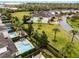 Aerial view of a backyard pool with a spa surrounded by lush greenery and nearby homes at 301 Pendant Ct, Kissimmee, FL 34747
