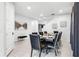 Contemporary dining room with seating for eight, light tile flooring, neutral walls, and modern decor at 301 Pendant Ct, Kissimmee, FL 34747
