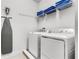 Convenient laundry room with washer, dryer, ironing board, and storage shelves at 301 Pendant Ct, Kissimmee, FL 34747