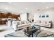 Open living room with neutral walls and tile flooring, contemporary furnishings, and a view into the kitchen at 301 Pendant Ct, Kissimmee, FL 34747