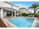 Backyard pool and spa surrounded by patio, lounge chairs, green landscaping, and a covered patio at 301 Pendant Ct, Kissimmee, FL 34747