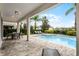 Relaxing outdoor pool area with covered patio, seating, lounge chairs, and lush landscaping at 301 Pendant Ct, Kissimmee, FL 34747