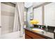 Elegant bathroom featuring a shower-tub combo, granite-topped vanity with yellow flowers, and decorative mirror at 3100 Stonewyck St, Orlando, FL 32824