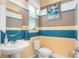 Charming powder room with a pedestal sink, toilet, and a striped accent wall creating a cozy and stylish space at 3100 Stonewyck St, Orlando, FL 32824