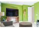Vibrant green living room with modern furniture, a large TV, and stylish lighting at 3100 Stonewyck St, Orlando, FL 32824