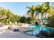 A Luxurious backyard oasis featuring a swimming pool, spa, and a rock grotto with lush tropical landscaping at 3100 Stonewyck St, Orlando, FL 32824