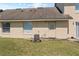 Exterior backyard view featuring a simple home design, window, door, and grass at 3112 Enclave Ct, Kissimmee, FL 34746