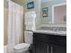 Bathroom featuring a shower with a decorative curtain, neutral walls, a dark vanity, and decorative art at 3112 Enclave Ct, Kissimmee, FL 34746