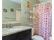 Bright bathroom with granite vanity, dark cabinets, and colorful shower curtain at 3112 Enclave Ct, Kissimmee, FL 34746