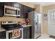 Efficient kitchen with stainless steel refrigerator and range, and granite countertops at 3112 Enclave Ct, Kissimmee, FL 34746