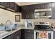 Well-equipped kitchen featuring dark cabinets, granite countertops, and stainless steel appliances at 3112 Enclave Ct, Kissimmee, FL 34746