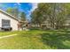 Large backyard with lush green grass, mature trees, and an outdoor seating area at 3189 Saint James Ave, Deltona, FL 32738