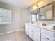Spacious bathroom featuring a double sink vanity, tiled flooring, and window at 410 Lark Ct, Kissimmee, FL 34759