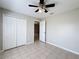 Bedroom features tile flooring, ceiling fan, and a closet at 410 Lark Ct, Kissimmee, FL 34759