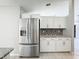 Contemporary kitchen featuring stainless steel refrigerator and sleek white cabinetry at 410 Lark Ct, Kissimmee, FL 34759