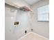 This laundry room includes tile flooring, a window for natural light, and shelving for storage at 410 Lark Ct, Kissimmee, FL 34759