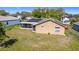Rear exterior view featuring solar panels on the roof and a screened lanai overlooking the grassy backyard at 410 Lark Ct, Kissimmee, FL 34759