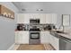 Modern kitchen with white cabinets, stainless steel appliances, and stylish backsplash at 413 Paloma Dr, Davenport, FL 33837