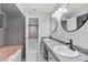 Bathroom featuring dual sinks, round mirrors, and tiled shower/bath at 4172 Stonehenge Rd, Mulberry, FL 33860