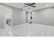 Spacious bedroom with ceiling fan and tile flooring, adjacent to bathroom and walk-in closet at 4172 Stonehenge Rd, Mulberry, FL 33860