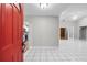 Inviting entryway with a bright red door and tiled flooring offers a glimpse into the home's interior at 4172 Stonehenge Rd, Mulberry, FL 33860