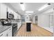 Open concept kitchen with stainless steel appliances, white cabinets, and a stylish island with seating at 4172 Stonehenge Rd, Mulberry, FL 33860