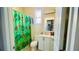Cozy bathroom has a single sink vanity, tiled flooring, and a shower with curtain at 419 Cierra Oaks Cir, Lady Lake, FL 32159