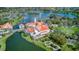 A captivating aerial view of a building complex with terracotta roofs, situated by a serene lake at 461 Treviso Dr, Kissimmee, FL 34759