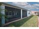 Exterior view of screened patio overlooking a lush green backyard at 461 Treviso Dr, Poinciana, FL 34759