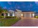 Beautiful single-story home featuring a brick driveway, stone accents, manicured landscaping and a two-car garage at 461 Treviso Dr, Poinciana, FL 34759