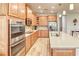 Gourmet kitchen featuring stainless steel appliances, wood cabinets, and quartz countertops at 461 Treviso Dr, Poinciana, FL 34759