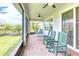 Relaxing screened lanai with comfortable seating, ceiling fans, and views of the surrounding yard and landscaping at 461 Treviso Dr, Poinciana, FL 34759