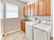 Laundry room area that has wooden cabinets, a stainless steel sink, and a washer and dryer at 461 Treviso Dr, Poinciana, FL 34759