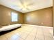 A well-lit bedroom with tile floors, a ceiling fan, and ample space at 602 N Delmonte Ct, Kissimmee, FL 34758