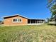 Single-story home with a screened-in porch and a well-maintained lawn under a clear blue sky at 602 N Delmonte Ct, Kissimmee, FL 34758