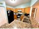 Cozy kitchen with granite counters, wood cabinetry, and stainless steel appliances at 602 N Delmonte Ct, Kissimmee, FL 34758