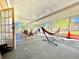 Enclosed sunroom with plenty of light, furnished with chairs and a hammock at 602 N Delmonte Ct, Kissimmee, FL 34758