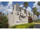 Hotel & Suites sign with lush landscaping and palm trees in front of the building on a sunny day at 6165 Carrier Dr # 2108, Orlando, FL 32819