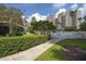 Well-maintained pool area with white fence and walkway next to the Enclave Hotel with beautiful landscaping at 6165 Carrier Dr # 2108, Orlando, FL 32819