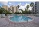 Large outdoor swimming pool and patio surrounded by chairs and lush landscaping at 6165 Carrier Dr # 2108, Orlando, FL 32819