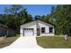 Modern, newly constructed single-story home with a bright white exterior, dark trim and an attached garage at 6862 Se 23Rd Ave, Ocala, FL 34480