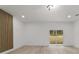 Large room with wood grain accent wall and a glass sliding door to the outside at 6862 Se 23Rd Ave, Ocala, FL 34480