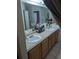 Bathroom featuring double sinks, a large mirror, and a neutral-toned countertop at 7143 Edgewater Shores Ct, Orlando, FL 32810