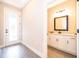 Bright foyer with wood flooring, ornate glass front door, and half bathroom at 7848 Somersworth Dr, Kissimmee, FL 34747