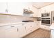 Bright kitchen features white cabinets, stainless steel appliances, and modern countertops at 7848 Somersworth Dr, Kissimmee, FL 34747