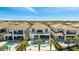 Aerial view showcasing a community of homes with multiple pools and greenery at 7921 Jacks Club Dr, Kissimmee, FL 34747