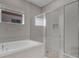 Bathroom featuring tub, glass enclosed shower with gray accent tile at 7921 Jacks Club Dr, Kissimmee, FL 34747